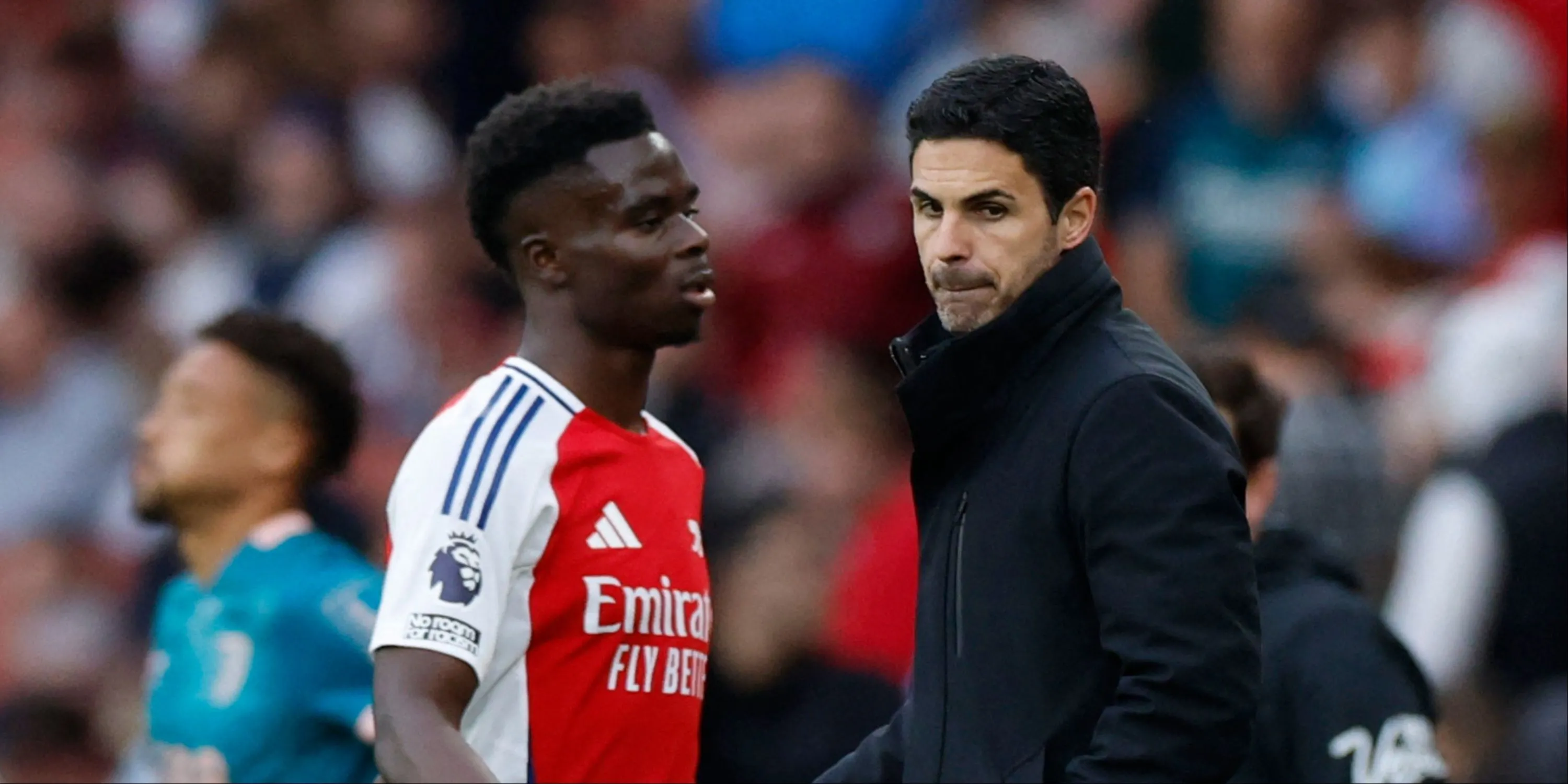HLV Mikel Arteta trao đổi cùng Bukayo Saka bên đường biên trong một trận đấu của Arsenal